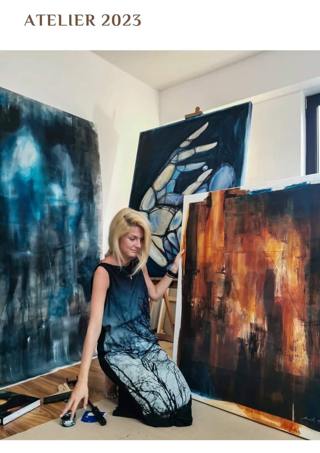The artist in the studio, alongside compositions in blue, white and ochre.
