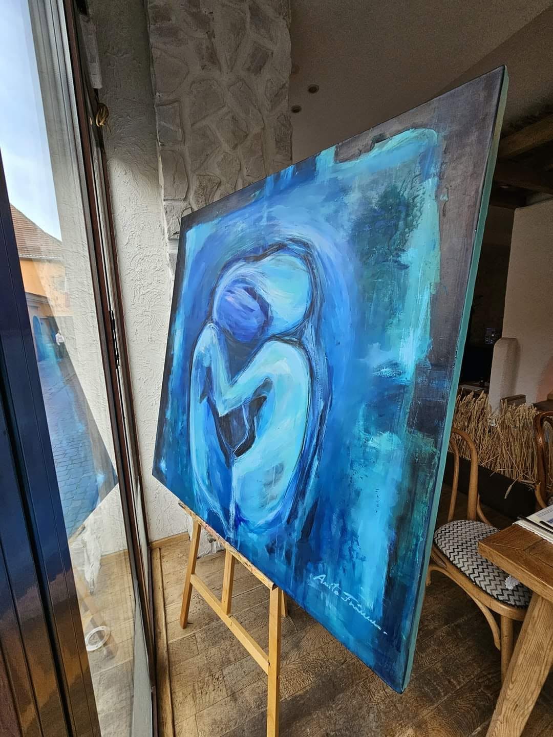 In Aeternum displayed on an easel beside a window.
